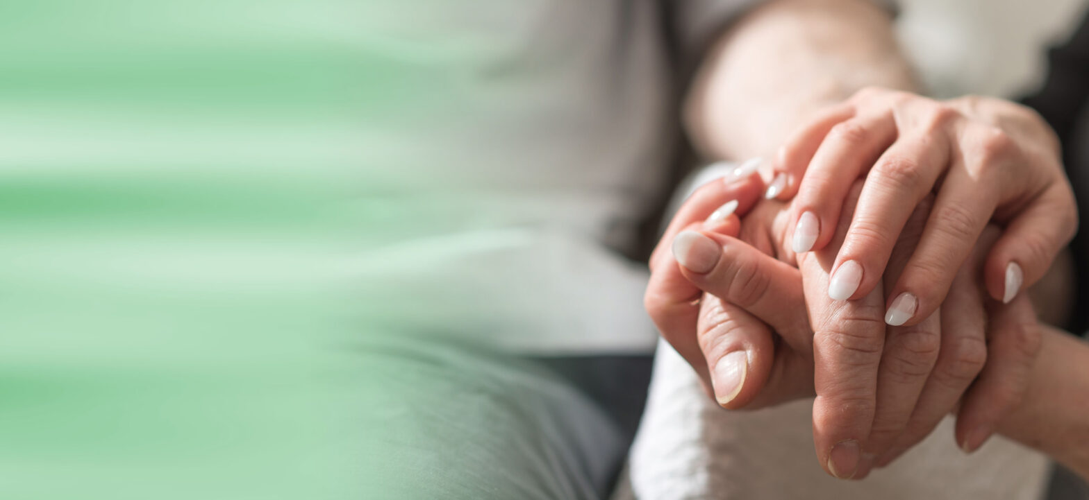 Hands of young woman holding the hands of an elderly person