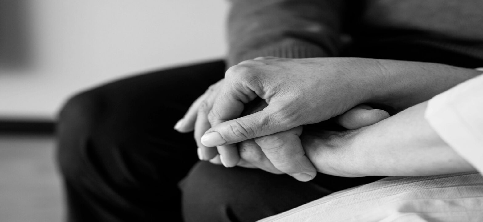 Two people holding hands, couple supporting one another