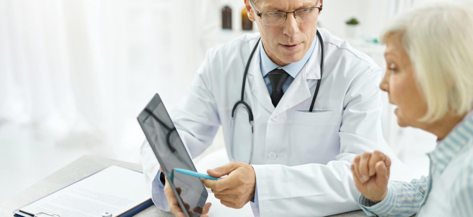Doctor on a tablet explaining treatment options to a patient.