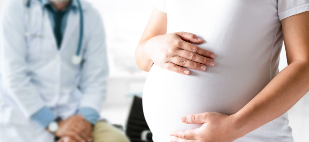Pregnant woman standing near doctor. Learning about pregnancy and nrSPMS