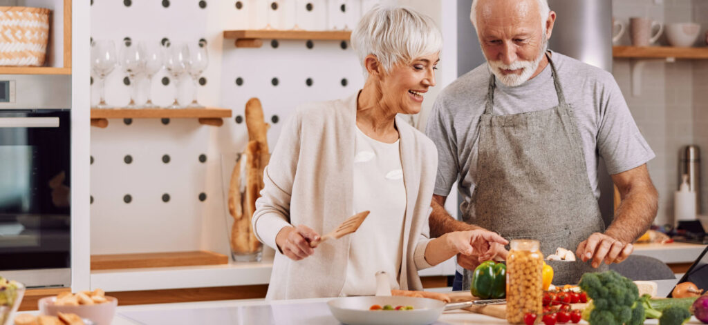 Older couple happy while cooking food
