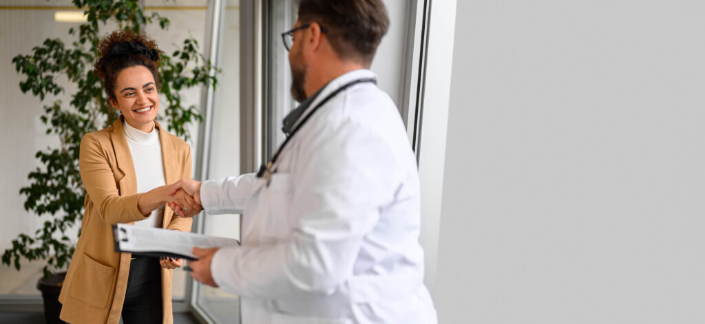 Patient shaking hands with doctor after leaving the office