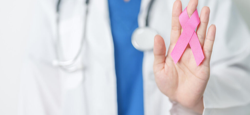 Doctor holding a breast cancer ribbon
