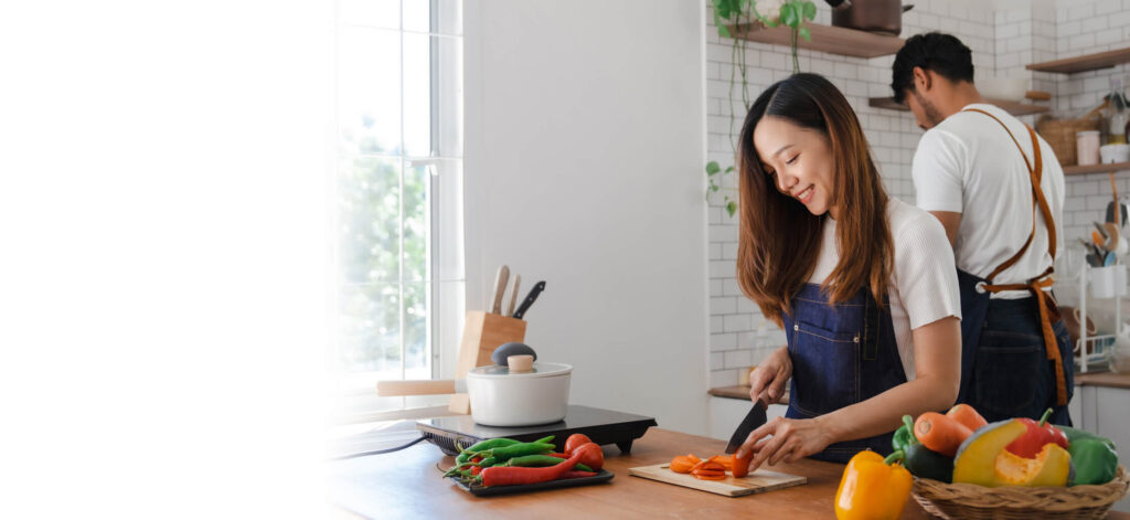 Happy couple preparing vegetables for dinner