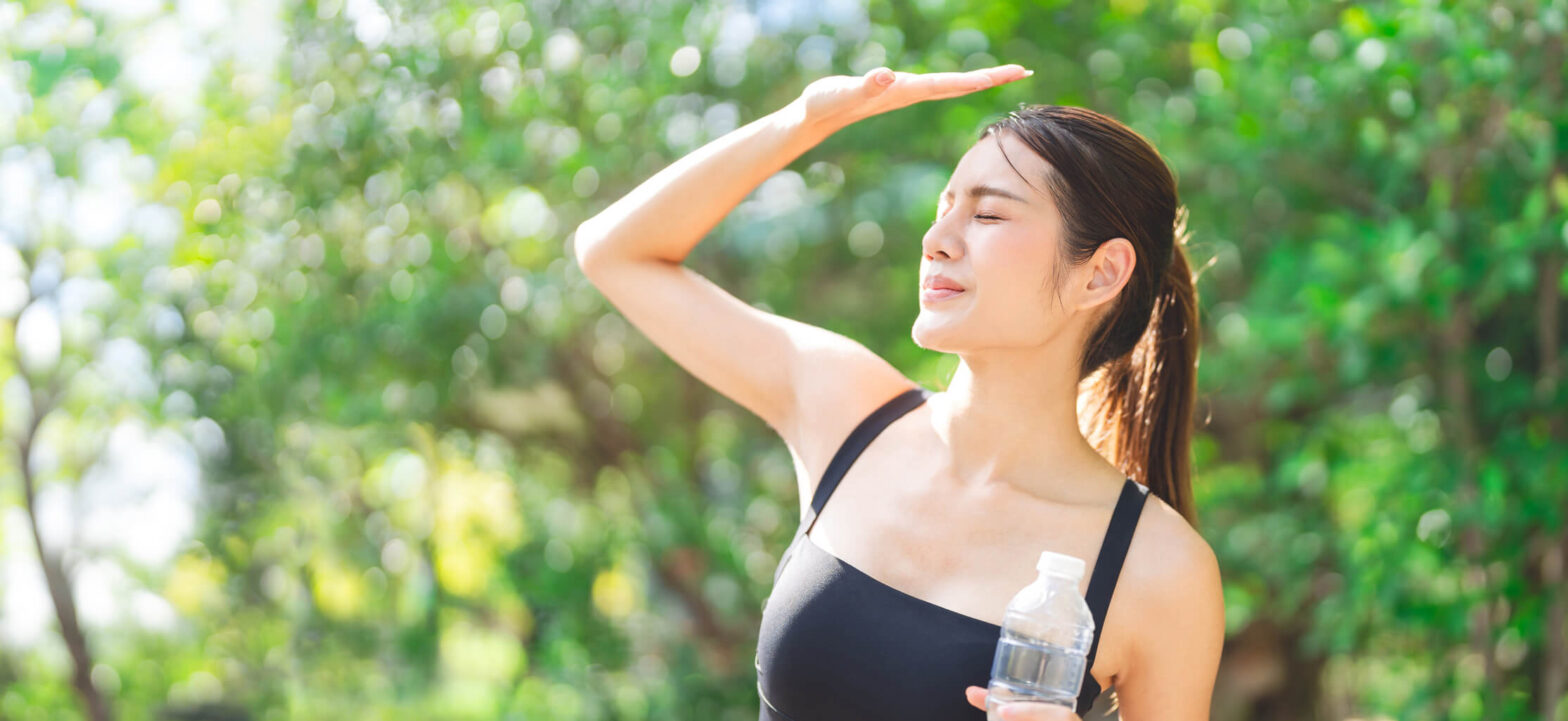 Woman shielding her face from the hot sun, ways of managing heat fatigue with CKD