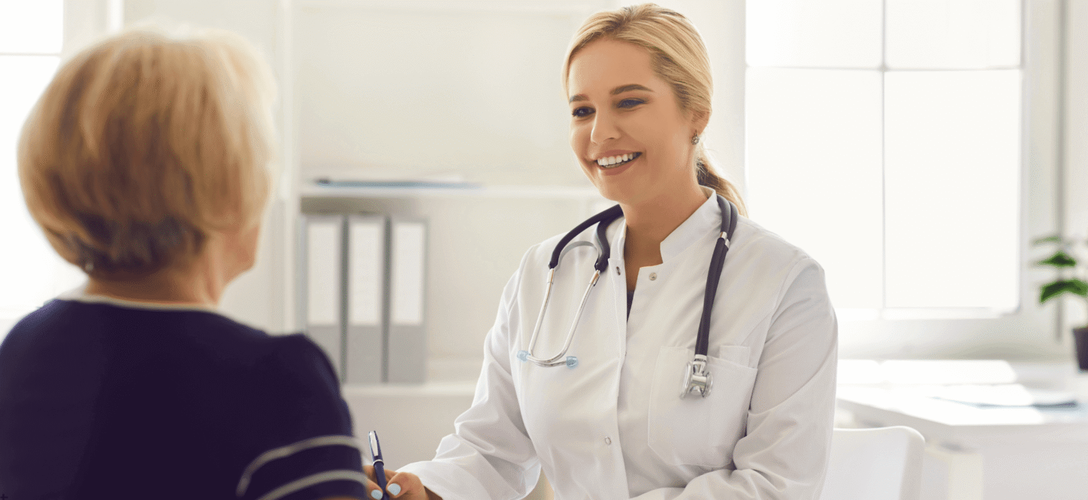 caucasian female doctor speaking to a blonde female elderly patient