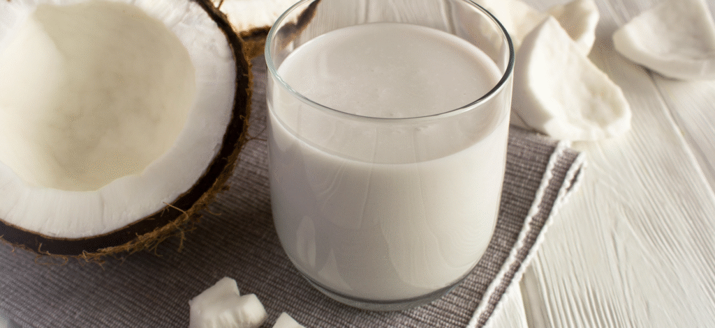 a glass of coconut milk and a coconut