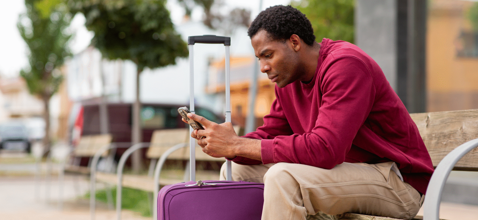 man on bench with suitcase