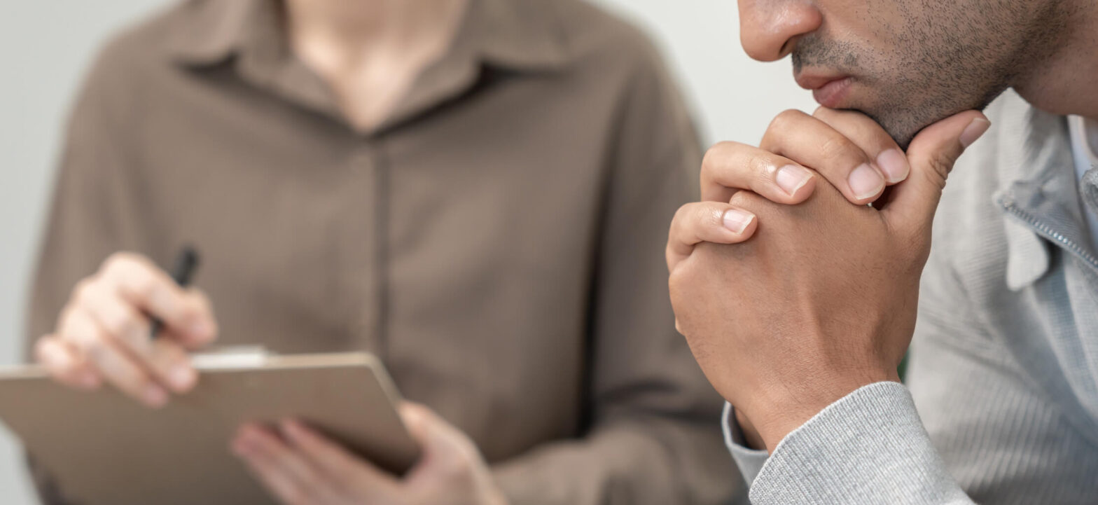 Man talking to therapist, trying to understand depression symptoms that do not look like sadness