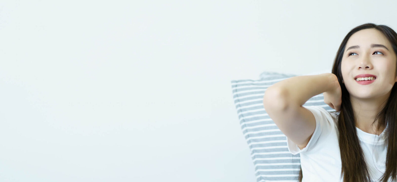 Woman stretching in bed after waking up, connection between resting and metabolic health