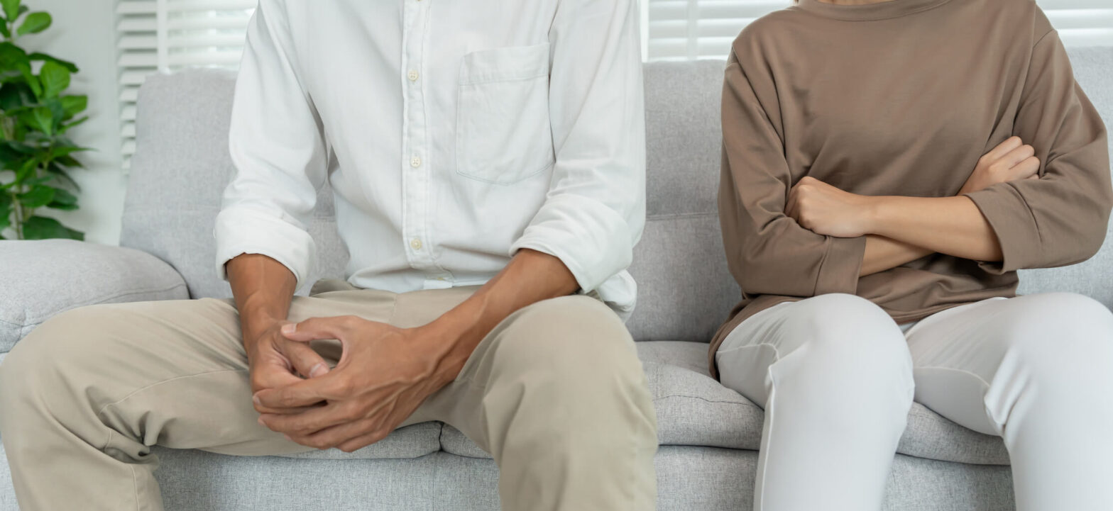 A couple sitting on a couch, having a disagreement. How depression can affect communication and relationships