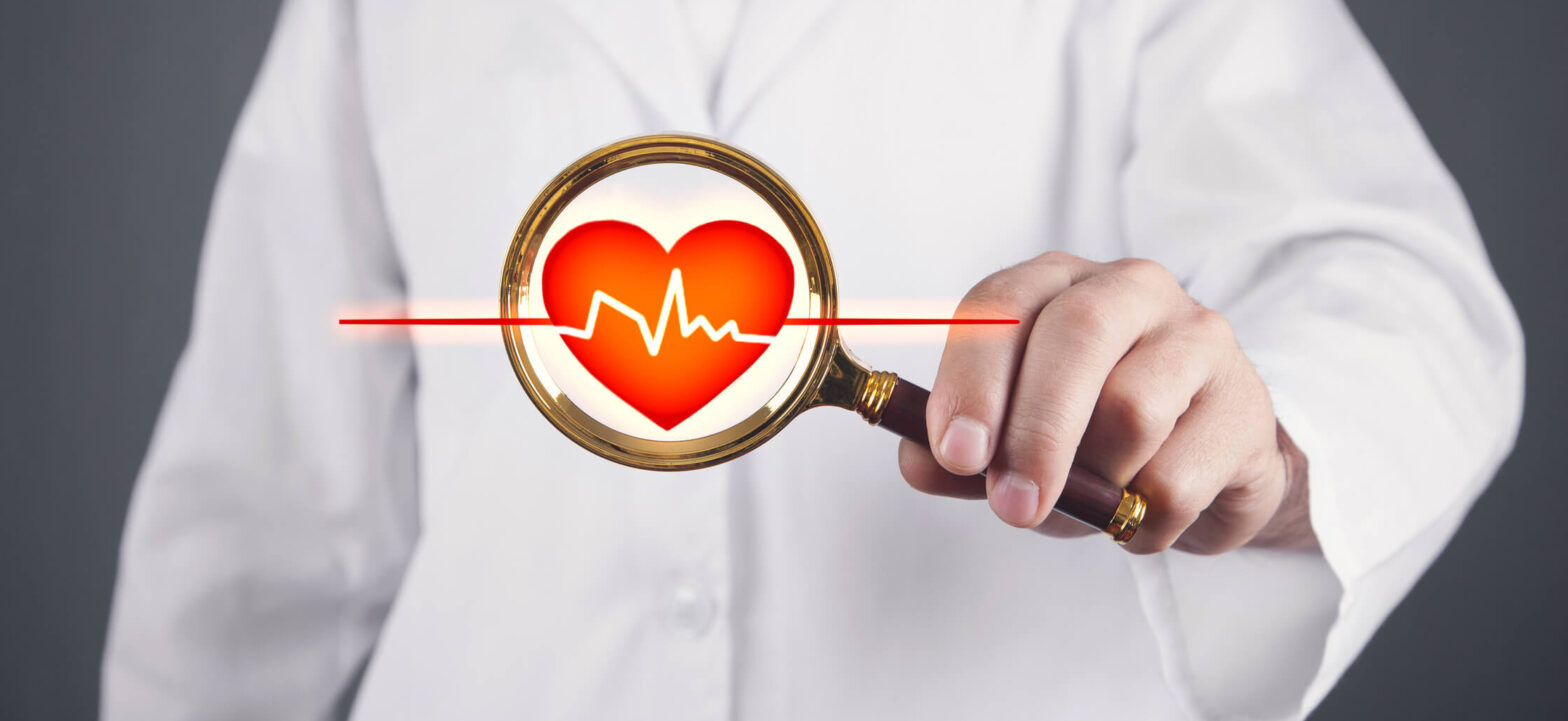 Doctor holding a magnifying glass up to a heart. Walking routine for improving heart health