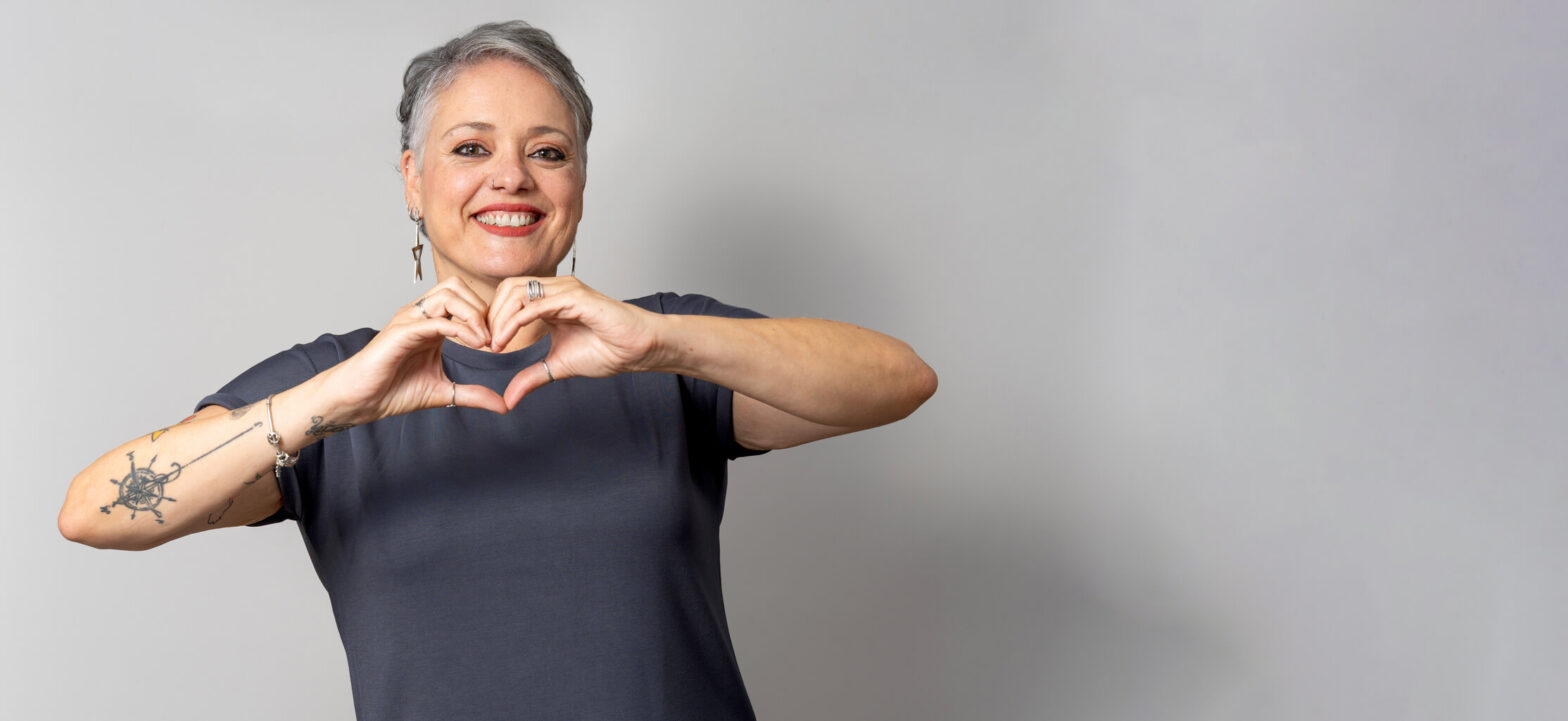 Woman holding up her hands in the shape of a heart, heart-related symptoms in women