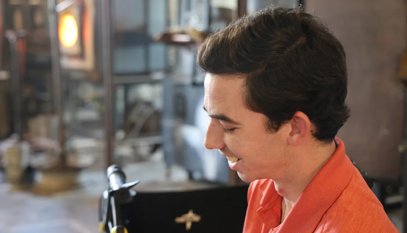 Image of Noah Griffith, near wheelchair smiling